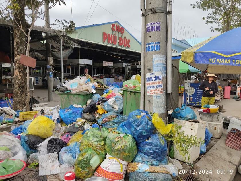 Tại chợ Phú Đức (xã Phú Đức) những thùng rác đã “quá tải” và rác chất cao thành đống (ẢNh: Báo PLVN)