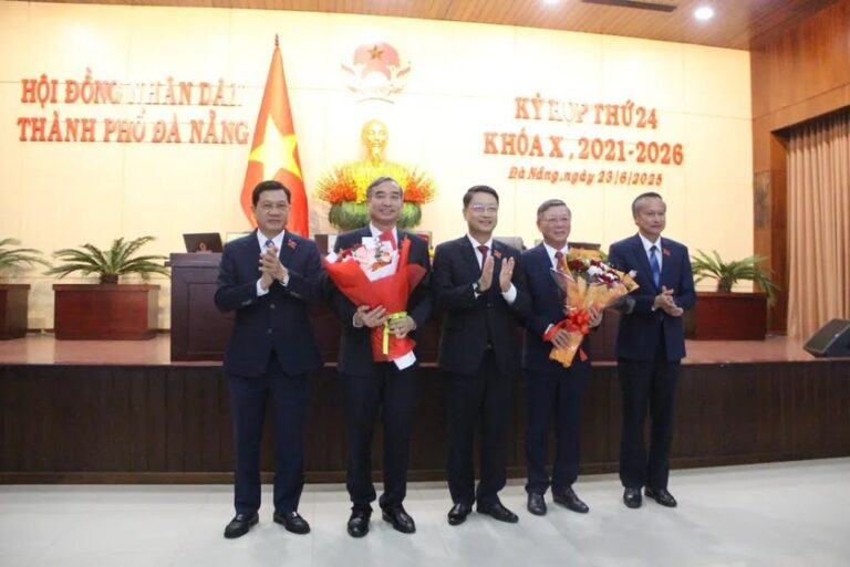HĐND TP Đà Nẵng tặng hoa cho ông Lê Trung Chinh và Lê Văn Trung. Ảnh: Báo PLVN
